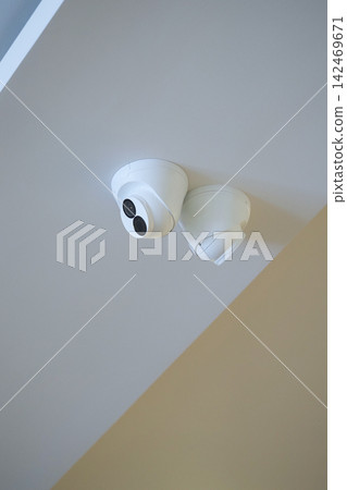 Security cameras installed on a ceiling in a room Security cameras installed on a ceiling in a room 142469671