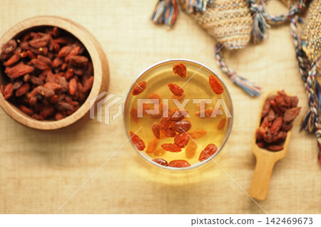 Goji berries in a glass of tea on a table Goji berries in a glass of tea on a table 142469673