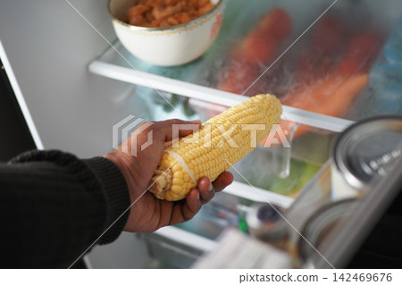 Inspecting corn in the fridge 142469676