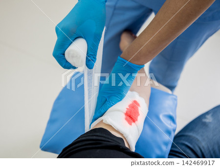Nurse dressing wound for patient's hand with deep skin cutting. Nurse dressing wound for patient's hand with deep skin cutting. 142469917