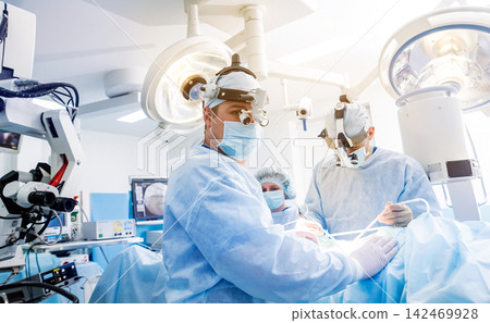 Portrait of spinal surgeon in operating room with surgery equipment. Portrait of spinal surgeon in operating room with surgery equipment. 142469928