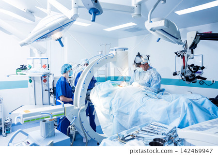 Spinal surgery. Group of surgeons in operating room with surgery equipment. Laminectomy Spinal surgery. Group of surgeons in operating room with surgery equipment. Laminectomy 142469947