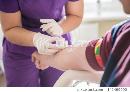 Nurse taking a patient's blood sample at lab 142469990