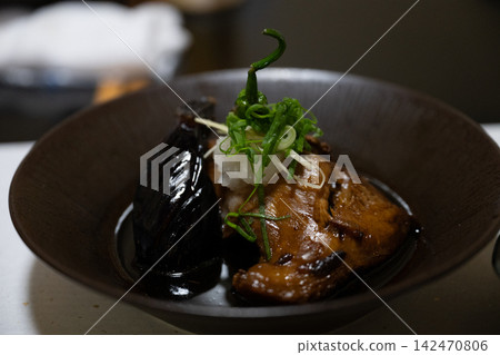 A dish of eggplant with a glossy soy sauce glaze and grilled meat. A dish of eggplant with a glossy soy sauce glaze and grilled meat. 142470806