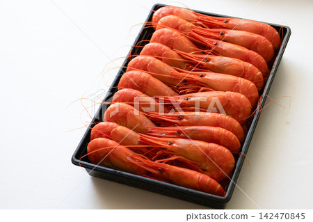 A photo of a tray of red shrimp viewed from an angle. 142470845