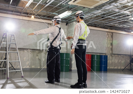 建築工地:安全檢查-一名男子正在檢查全身式安全帶的貼合度。 建築工地:安全檢查-一名男子正在檢查全身式安全帶的貼合度。 142471027