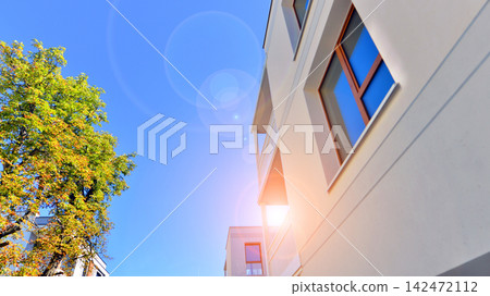 European residential architecture harmonizing with nature. Eco-friendly living in city with greens. Eco apartment building saving energy and fresh air concept. European residential architecture harmonizing with nature. Eco-friendly living in city with greens. Eco apartment building saving energy and fresh air concept. 142472112