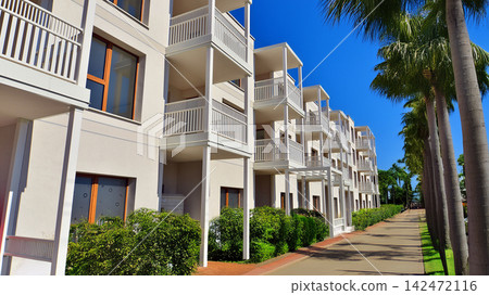 European residential architecture harmonizing with nature. Eco-friendly living in city with greens. Eco apartment building saving energy and fresh air concept. European residential architecture harmonizing with nature. Eco-friendly living in city with greens. Eco apartment building saving energy and fresh air concept. 142472116