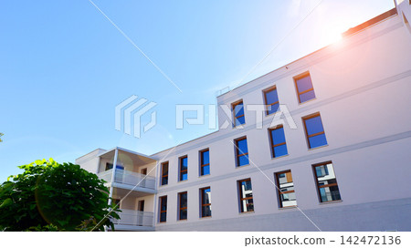 European residential architecture harmonizing with nature. Eco-friendly living in city with greens. Eco apartment building saving energy and fresh air concept. 142472136
