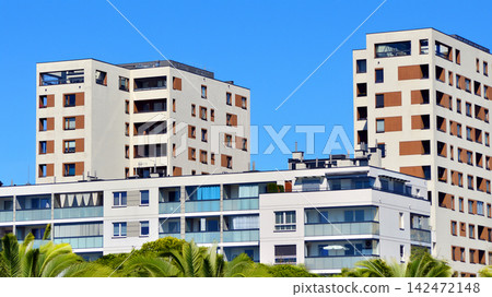 European residential architecture harmonizing with nature. Eco-friendly living in city with greens. Eco apartment building saving energy and fresh air concept. European residential architecture harmonizing with nature. Eco-friendly living in city with greens. Eco apartment building saving energy and fresh air concept. 142472148