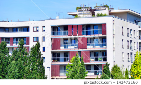 European residential architecture harmonizing with nature. Eco-friendly living in city with greens. Eco apartment building saving energy and fresh air concept. European residential architecture harmonizing with nature. Eco-friendly living in city with greens. Eco apartment building saving energy and fresh air concept. 142472160