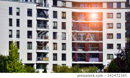 European residential architecture harmonizing with nature. Eco-friendly living in city with greens. Eco apartment building saving energy and fresh air concept. European residential architecture harmonizing with nature. Eco-friendly living in city with greens. Eco apartment building saving energy and fresh air concept. 142472165