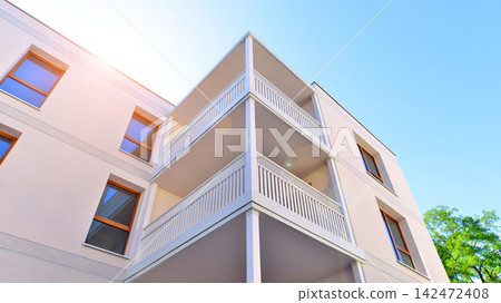 Modern apartment buildings on a sunny day with a blue sky. Facade of a modern apartment building. Glass surface with sunlight. Modern apartment buildings on a sunny day with a blue sky. Facade of a modern apartment building. Glass surface with sunlight. 142472408