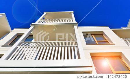 Modern apartment buildings on a sunny day with a blue sky. Facade of a modern apartment building. Glass surface with sunlight. Modern apartment buildings on a sunny day with a blue sky. Facade of a modern apartment building. Glass surface with sunlight. 142472420