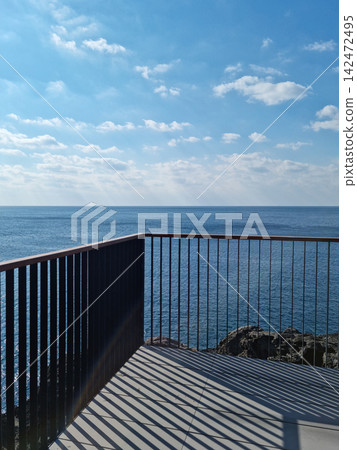 It is a seascape with a railing. It is a seascape with a railing. 142472495