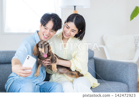 與狗相伴的家庭生活;一對夫婦和他們心愛的狗狗一起拍照。 與狗相伴的家庭生活;一對夫婦和他們心愛的狗狗一起拍照。 142472923