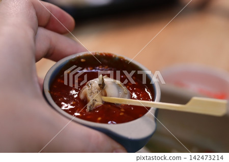 Hand Holding Bowl of Spicy Seafood Dip Hand Holding Bowl of Spicy Seafood Dip 142473214