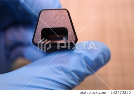 Gloved Hand Holding Small Electronic Component Gloved Hand Holding Small Electronic Component 142473230