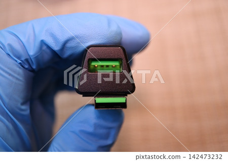 Gloved Hand Holding USB Connector Close-Up 142473232