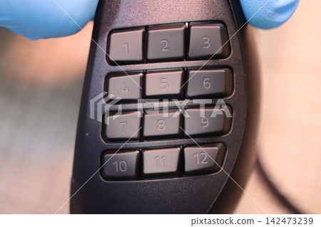Close-up of numeric keypad with blue-gloved hands Close-up of numeric keypad with blue-gloved hands 142473239