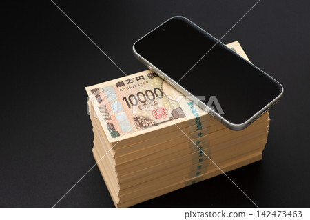 一疊1000萬日圓現金和一部智慧型手機 一疊1000萬日圓現金和一部智慧型手機 142473463
