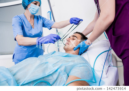 Doctors give resuscitation to a male patient in the emergency room. Cardiac massage Doctors give resuscitation to a male patient in the emergency room. Cardiac massage 142473914
