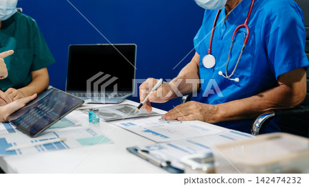 A dedicated medical team discusses patient diagnostics, reviewing brain MRIs and medical charts on digital devices A dedicated medical team discusses patient diagnostics, reviewing brain MRIs and medical charts on digital devices 142474232