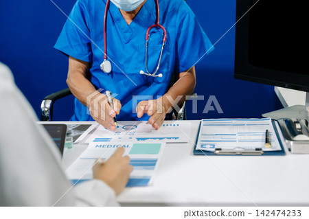 A dedicated medical team discusses patient diagnostics, reviewing brain MRIs and medical charts on digital devices A dedicated medical team discusses patient diagnostics, reviewing brain MRIs and medical charts on digital devices 142474233