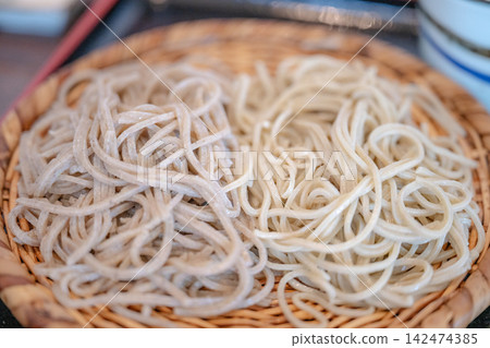 擺放在竹托盤上的雙色蕎麥麵的特寫。 擺放在竹托盤上的雙色蕎麥麵的特寫。 142474385