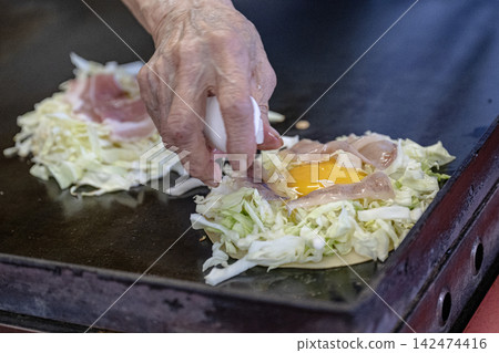 用豬肉和雞蛋製作大阪燒的過程。 用豬肉和雞蛋製作大阪燒的過程。 142474416