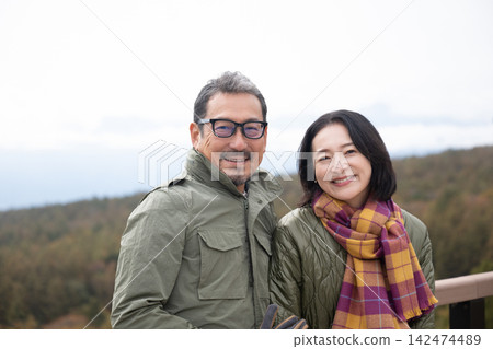一對中年夫婦正在欣賞清里高原的全景。 一對中年夫婦正在欣賞清里高原的全景。 142474489