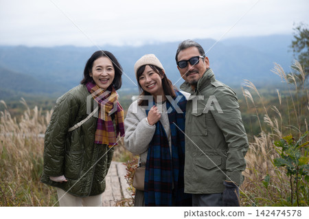 三個朋友依偎在秋日的木板路上。 三個朋友依偎在秋日的木板路上。 142474578