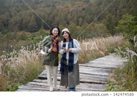 女性朋友沿著可以俯瞰八嶽山脈的木棧道漫步。 女性朋友沿著可以俯瞰八嶽山脈的木棧道漫步。 142474580