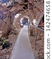 Ancient underground stone tunnels or mine shafts and dirt paths 142474658