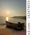 Abandoned fishing boats on the beach at dusk 142474659