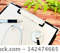 Stethoscope and clipboard on a wooden table 142474665