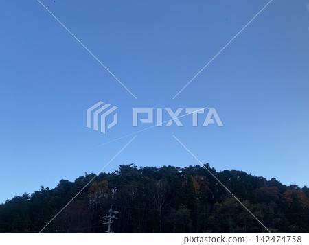 深秋的天空:一道明亮的白色尾跡筆直地橫跨在藍天之上。 深秋的天空:一道明亮的白色尾跡筆直地橫跨在藍天之上。 142474758