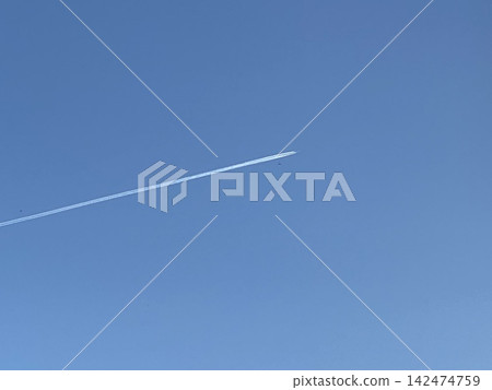 一道白色的尾跡筆直地劃過湛藍的天空。 一道白色的尾跡筆直地劃過湛藍的天空。 142474759