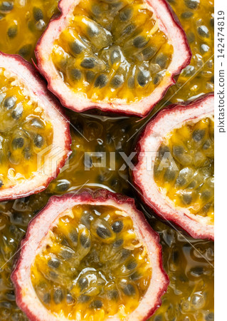 Top view of ripe maracuja halves lying on background of seeds and pulp Top view of ripe maracuja halves lying on background of seeds and pulp 142474819