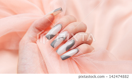Woman's hand with long pink and gray nail art Woman's hand with long pink and gray nail art 142474882