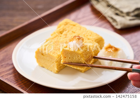 Japanese-style egg dish: Rolled omelet with dashi broth, served with grated daikon radish. Japanese-style egg dish: Rolled omelet with dashi broth, served with grated daikon radish. 142475158