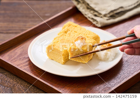 Japanese-style egg dish: Rolled omelet with dashi broth, served with grated daikon radish. Japanese-style egg dish: Rolled omelet with dashi broth, served with grated daikon radish. 142475159