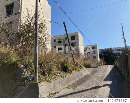 池島通往原煤礦住宅區的狹窄傾斜道路和混凝土擋土牆。 池島通往原煤礦住宅區的狹窄傾斜道路和混凝土擋土牆。 142475287