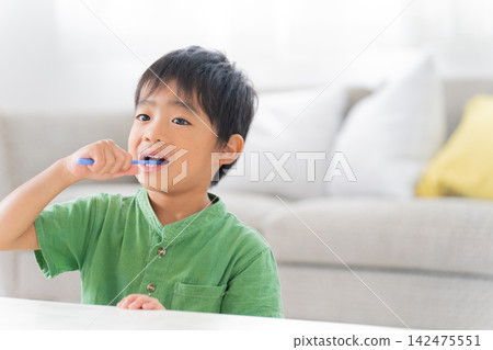 一個孩子正在用牙刷刷牙 一個孩子正在用牙刷刷牙 142475551