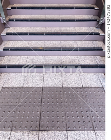A clean stone staircase with tactile paving for accessibility. A clean stone staircase with tactile paving for accessibility. 142475892