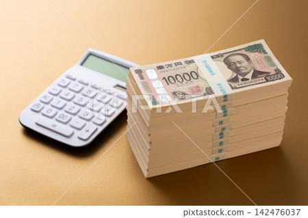 一疊900萬日圓鈔票和一個計算器 142476037