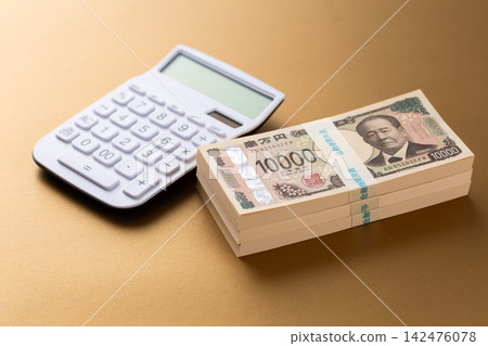 一疊300萬日元鈔票和一個計算器 一疊300萬日元鈔票和一個計算器 142476078