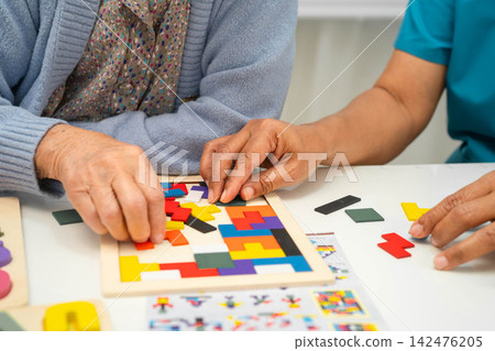 Asian elderly woman playing game with caregiver for train memory. Asian elderly woman playing game with caregiver for train memory. 142476205