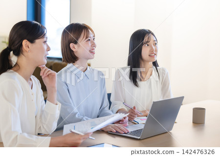 Female business professionals who listen attentively and positively to presentations and speeches in meetings. Female business professionals who listen attentively and positively to presentations and speeches in meetings. 142476326