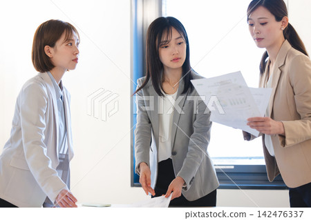 A businesswoman having a meeting in the office while looking at documents. 142476337